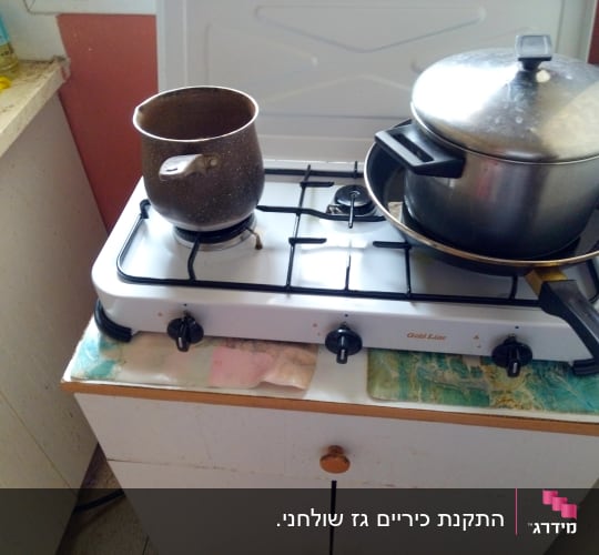 כיריים גז עם סירים ומחבת במטבח